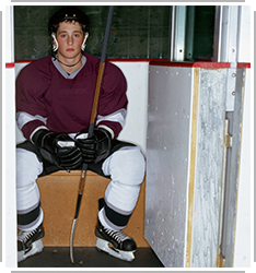 young hockey player sitting on bench