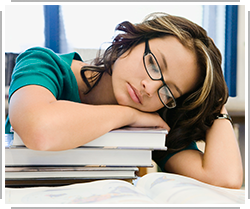 young woman asleep on stack of books