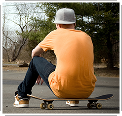 young man sitting on skateboard